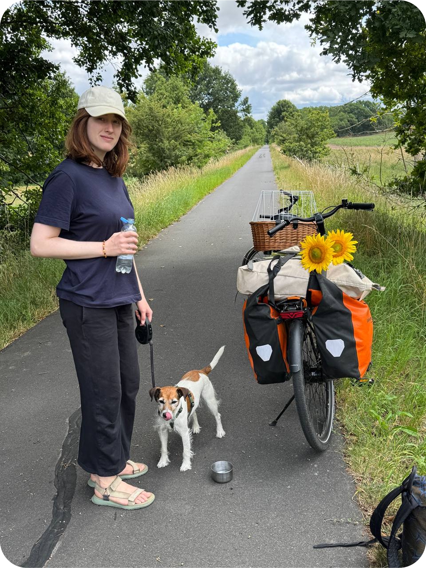 Sonja with her bike and dog on a country path